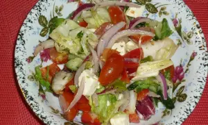 Pyszna sałatka z mix sałat, pomidorów, ogórka, czerwonej cebuli i sera feta, polana ziołowym dressingiem.