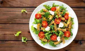 Kolorowa sałatka z makaronem fusilli, pomidorkami koktajlowymi, brokułami i fetą, polana musztardowym dressingiem. Pyszne danie na lekki obiad.