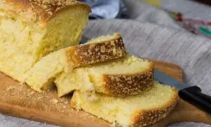 Szybkie ciasto drożdżowe bez wyrabiania, pokrojone na kromki, z kruszonką na wierzchu, leży na desce.