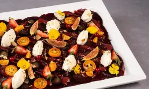 Eleganckie carpaccio z buraka z kawałkami fig, truskawek, kumkwatów, serka i jadalnych kwiatów.