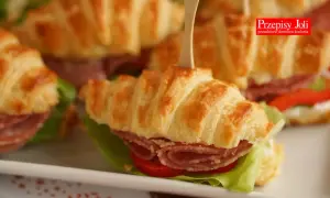 Pyszne rogaliki z ciasta francuskiego, nadziewane wędliną i warzywami, idealne na przekąskę.
