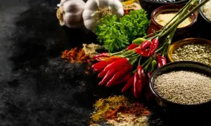 Czosnek, papryczki chili i zioła – idealne jakie przyprawy do indyka. Obok miseczki z ryżem, fasolą i kaszą.