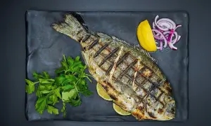 Grillowana ryba z cytryną, cebulą i natką pietruszki. Idealne jakie przyprawy do ryby na obiad.