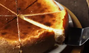 Pyszny, pokrojony sernik z lekko przypieczoną skórką. Czy sernik po upieczeniu zostawić w piekarniku? To pytanie nurtuje wielu piekarzy.