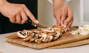 Krojenie pieczarek na desce. Czy pieczarki trzeba obierać? Zazwyczaj nie, wystarczy je oczyścić.