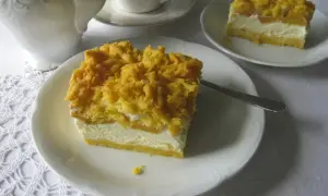 Sernik z brzoskwiniami, puszysty i lekki, z chrupiącą kruszonką. Idealny na deser.