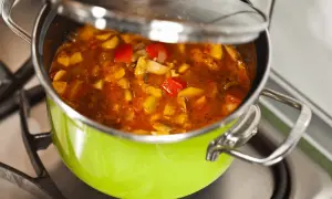 Gulasz w zielonym garnku na kuchence. Chcesz wiedzieć, jak zmniejszyć ostrość potrawy? Dodaj śmietanę lub jogurt.