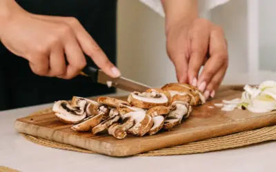 Krojenie pieczarek na desce. Czy pieczarki trzeba obierać? Zazwyczaj nie, wystarczy je oczyścić.