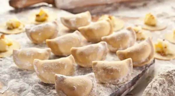 Gotowe do lepienia pierogi, posypane mąką. Zastanawiasz się, jaka mąka na pierogi będzie najlepsza? Ta wygląda idealnie!