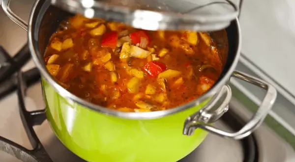 Gulasz w zielonym garnku na kuchence. Chcesz wiedzieć, jak zmniejszyć ostrość potrawy? Dodaj śmietanę lub jogurt.