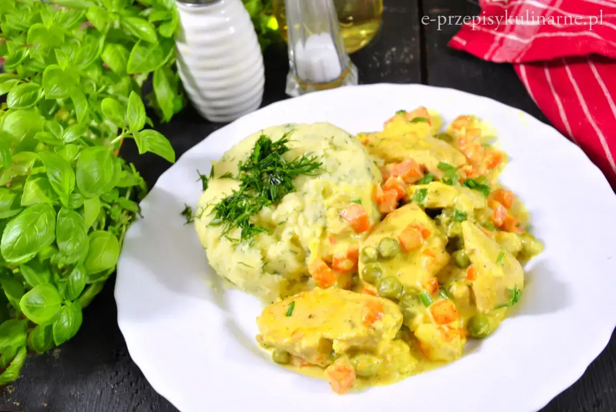 Pyszna potrawka z kurczaka w kremowym sosie z marchewką i groszkiem, podana z puree ziemniaczanym.
