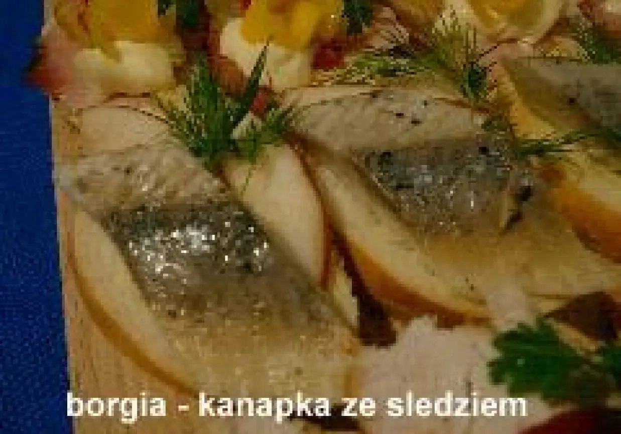 Kawałki pieczywa z wędzoną rybą, koprem i jajkiem. Pyszna kanapka ze śledziem na desce.